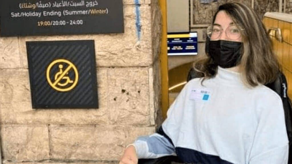 ליחי פרנקו, ליד השלט "אין כניסה לנכים" בלכרמלית. צילום - באדיבות המצולמת