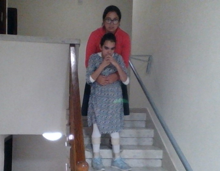 דסי, אחותה של תמר, עוזרת לה לרדת במדרגות לממ"ד בזמן אזעקה. צילום: באדיבות המשפחה