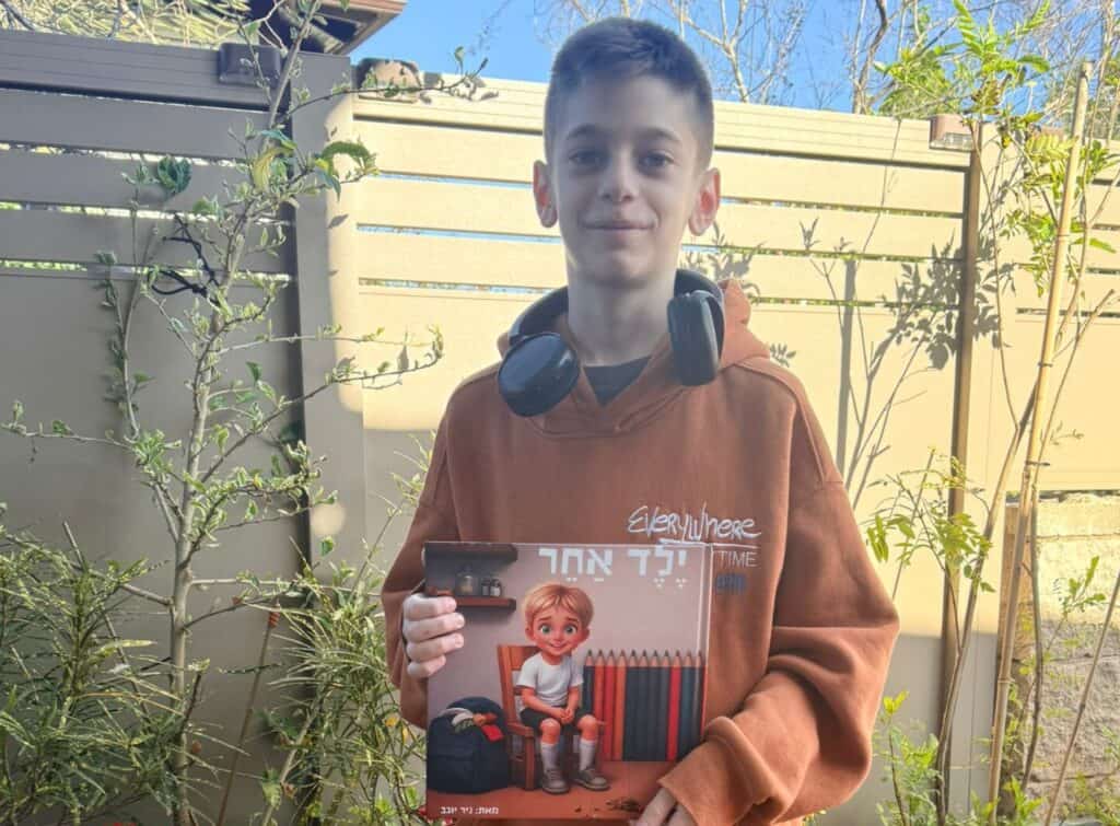 דן יוגב עם הספר שאביו ניר כתב (באדיבות המשפחה)
